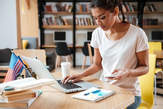 A student sitting at a desk, using a laptop with the website of the U.S. Department of Education visible on the screen, showcasing online resources for student loan information and applications.