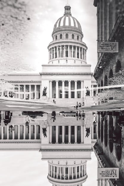 A split image showing the California State Capitol Building on one side and a group of rideshare drivers protesting on the other. This illustrates the tension and debate surrounding AB5 and its impact on the gig economy.