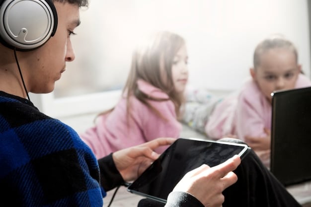 A young student wearing headphones and using a tablet in a brightly lit classroom. Other students are working on computers in the background.