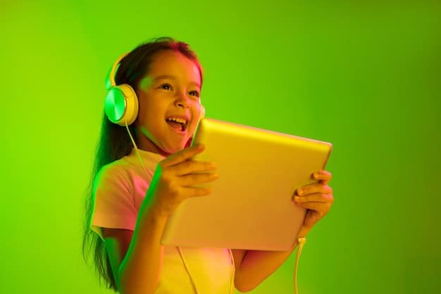 A student wearing headphones, focused on a tablet displaying an interactive learning app with colorful graphics and animated characters. The background is a blurred study environment with books and other learning materials.