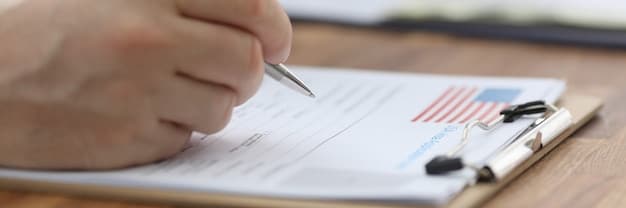 A close-up shot of a hand filling out an unemployment benefits application form.