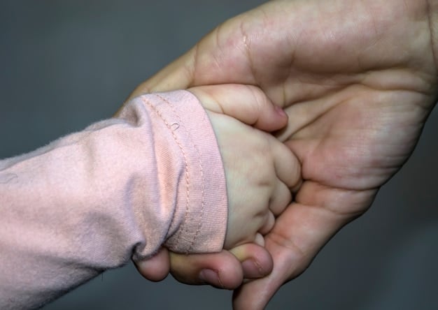 A close-up of a hand holding a baby's hand, symbolizing the caregiving aspect of Paid Family Leave. Light and warm tones evoke feelings of comfort and support.
