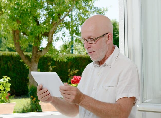 The image portrays a senior citizen using a tablet to compare different Medicare Advantage plans, possibly while consulting with a healthcare advisor over a video call. The scene emphasizes the convenience and accessibility of researching healthcare options online. The tablet screen displays plan details and key benefits. The image shows the benefits of using 'The Ultimate Guide to Understanding and Utilizing Your Medicare Benefits in 2025' to assist in selecting a comprehensive Medicare Advantage plan.